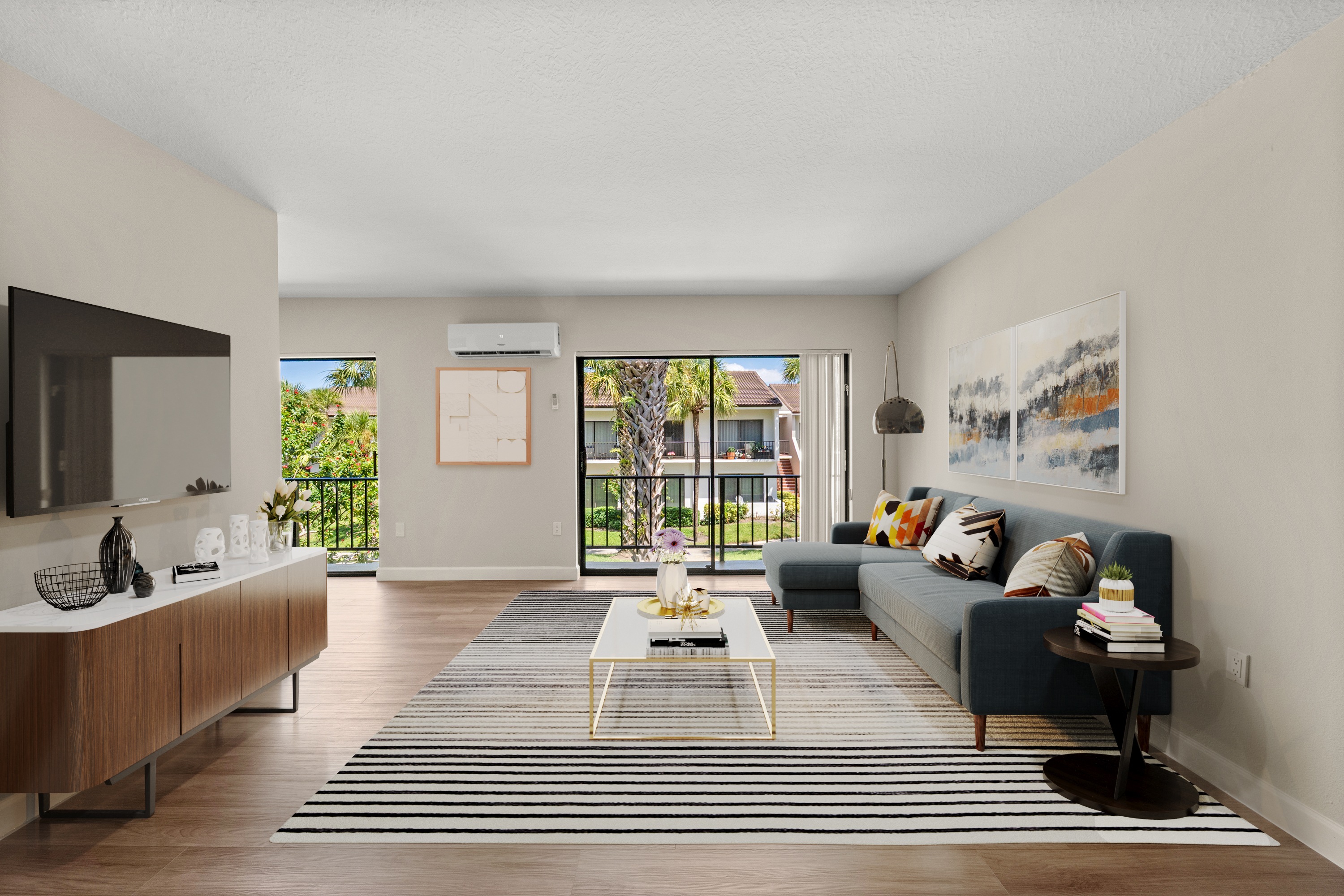 A living room with a couch, a coffee table, and a large window.
